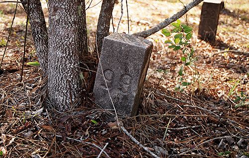 At the potter's field near our old home in the woods, south of town, some of the old stone markers have tilted over the decades for a variety of reasons.  Almost all of them are numbered. (2005)