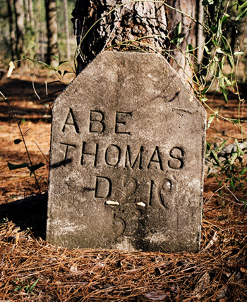 The old gravestone for Abe Thomas was my first confirmation of what these numbered posts of stone were marking.  Note how the tree is growing up over the rough-hewn tombstone.  If you know what the backwards 9 is all about, let me know.  (2005)