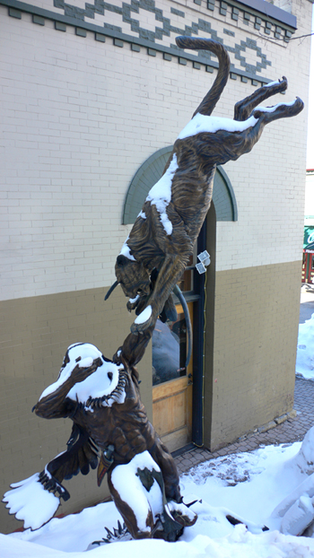 Statue in Park City, Utah, of an indian trying to get a shot off with his bow and arrow at a leaping mountain lion.  (2006)
