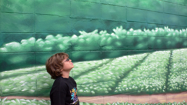 Alex playing farmer in front of an appropriately bucolic mural.  (2008)